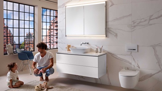 Homme et enfant dans une salle de bains blanche de la ligne Geberit ONE Homme et enfant dans une salle de bains blanche de la ligne Geberit ONE