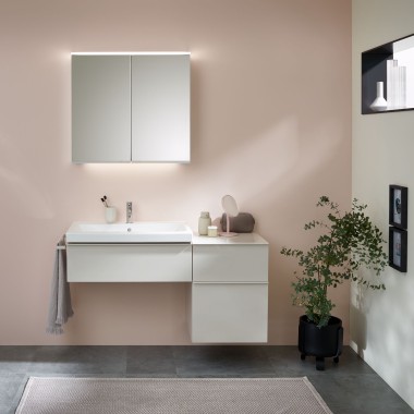 Washplace with bathroom furniture, washbasin and mirror cabinet from Geberit in front of a pastel wall